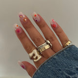 Hand wearing an Iced Jumbo Letter Ring with stacked gold rings