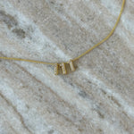 Close-up of the Baby Angel Number Necklace in 111 on marble