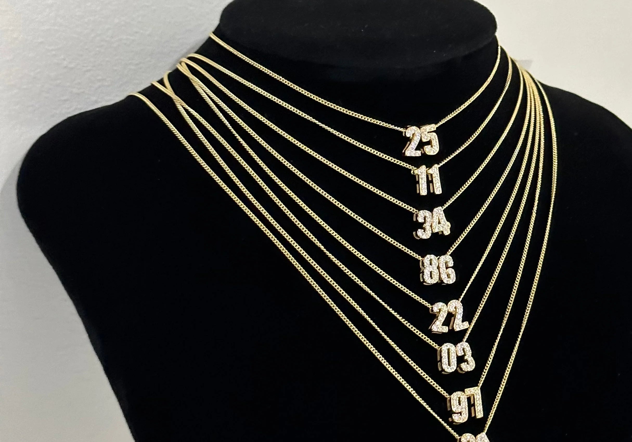 Baby CZ Double Digit Number Necklaces in different numbers on a display