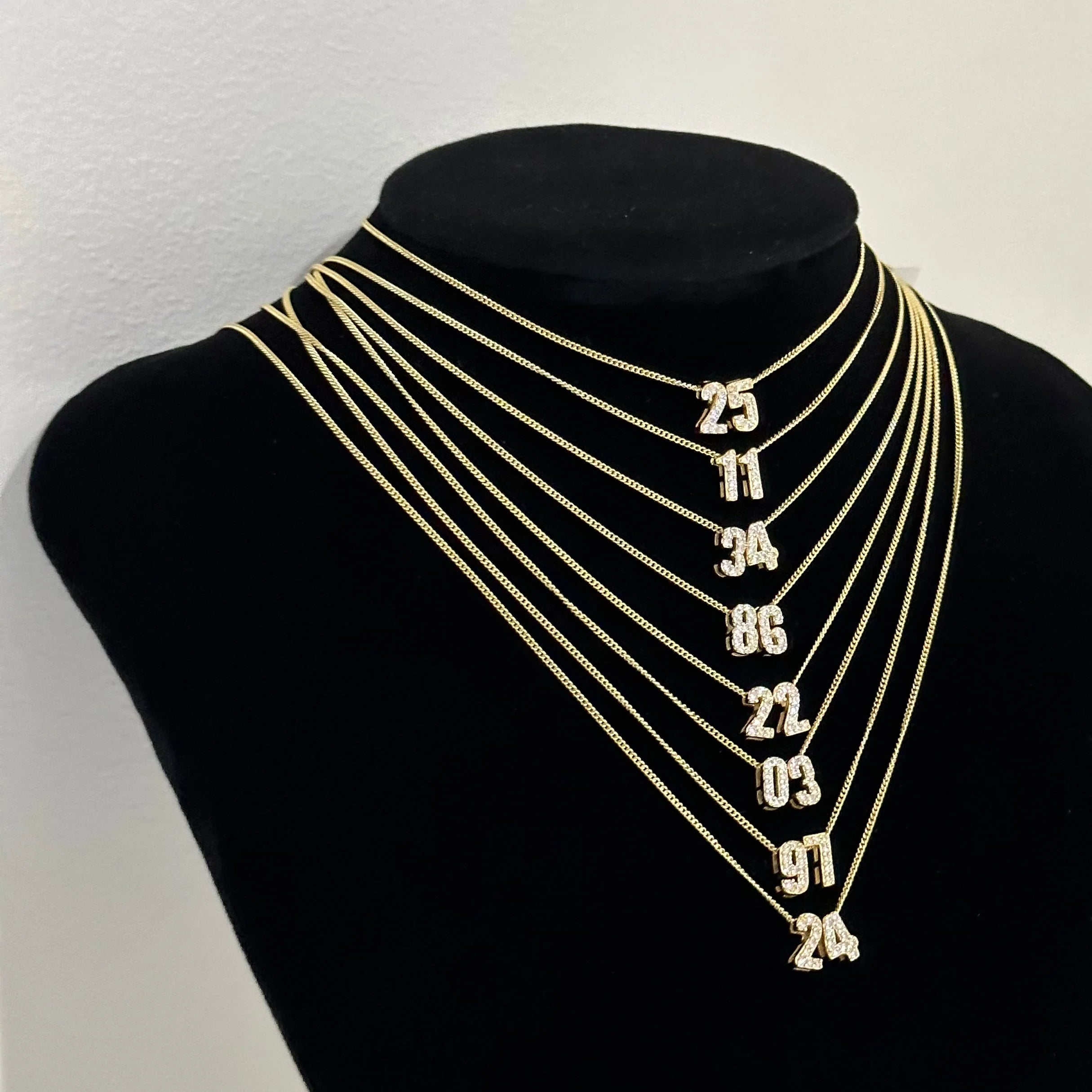 Baby CZ Double Digit Number Necklaces in different numbers on a display