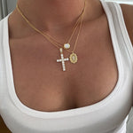 CZ Bezel Necklace layered with CZ cross and medallion necklaces over a white tank