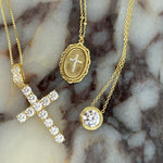 CZ Bezel Necklace with a CZ cross and cross medallion necklace on marble