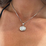 Model wearing a silver birthstone necklace with a clear stone on a box chain