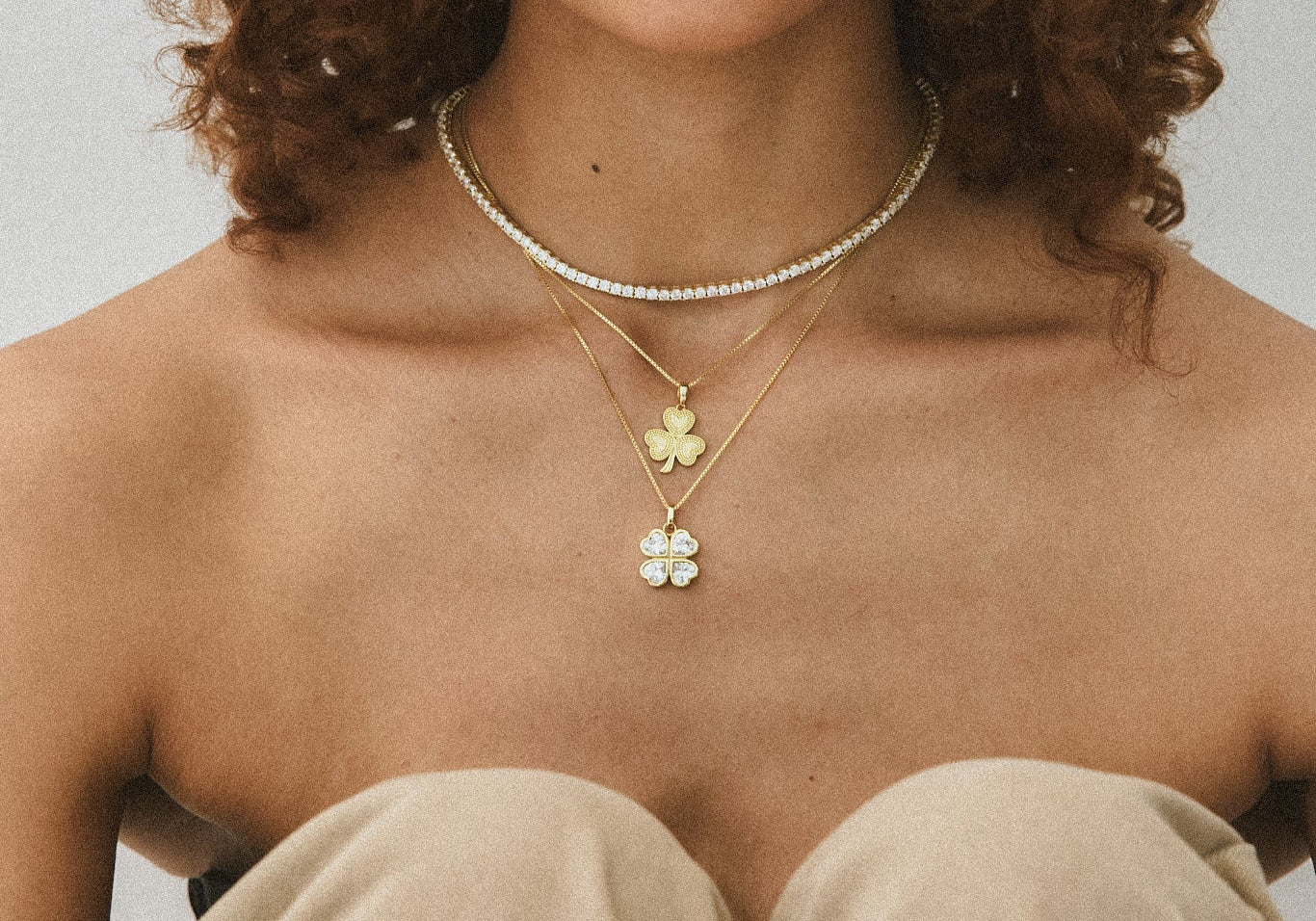 Model in a strapless top wearing the CZ Lucky 4 Me Necklace layered with a tennis necklace