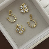 Gold four-leaf clover and horseshoe CZ pendants in a jewelry tray