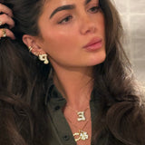 Model wearing a four-leaf clover CZ pendant layered with a horseshoe necklace