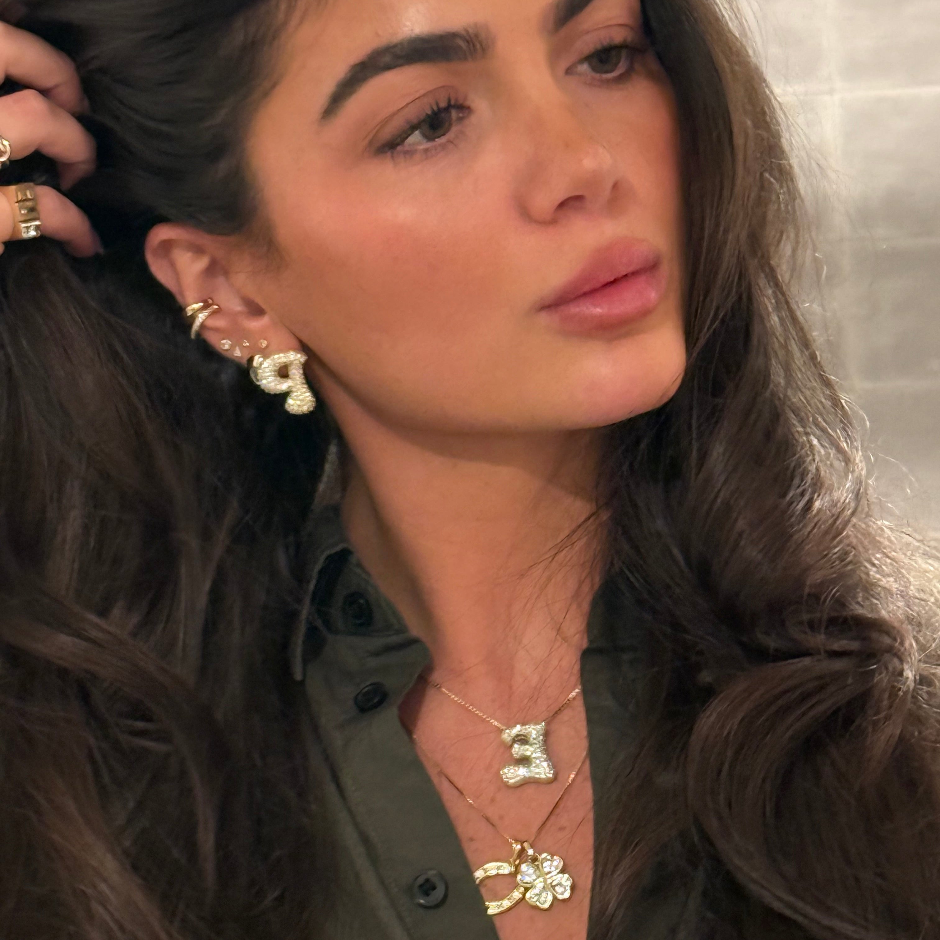 Model wearing a four-leaf clover CZ pendant layered with a horseshoe necklace