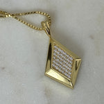 Close-up of the gold CZ Taylor pendant on a box chain on marble