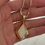 Hand holding the gold CZ Taylor Necklace on a box chain