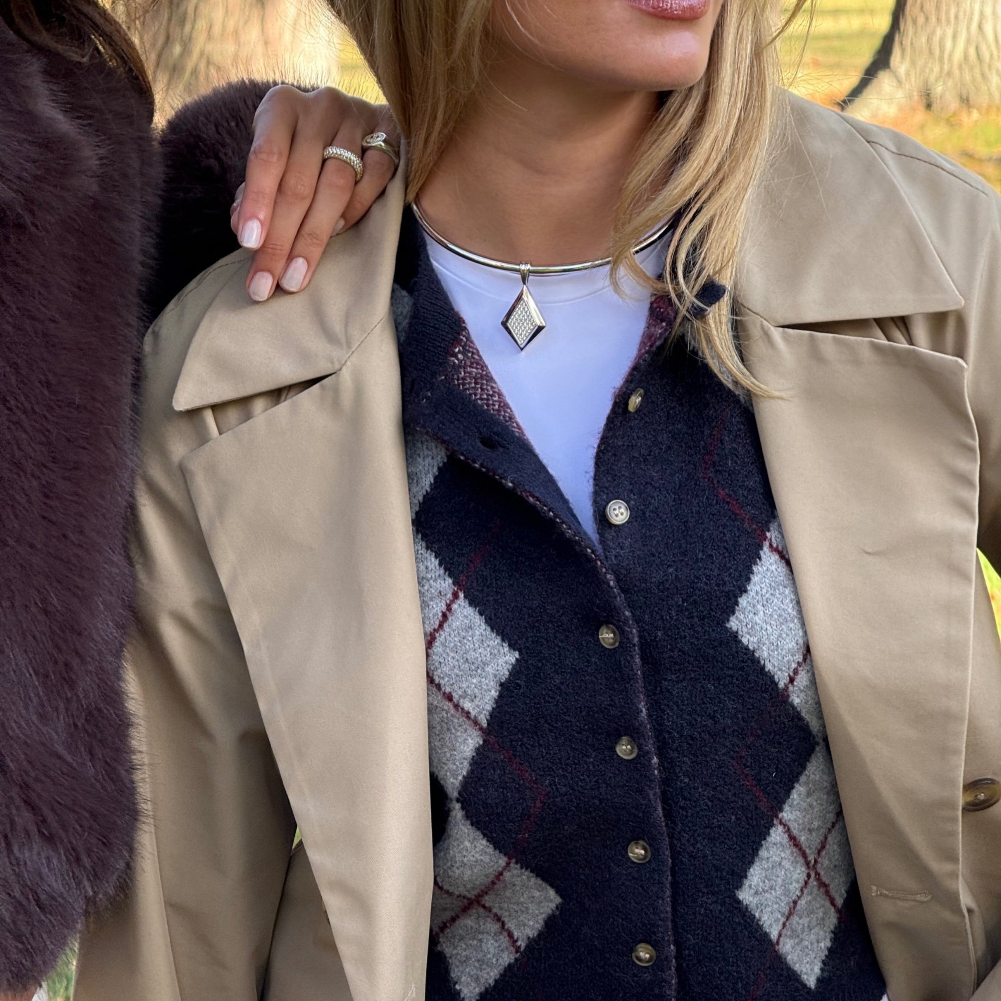 Model in a trench coat and argyle cardigan wearing the CZ Taylor Necklace