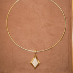 CZ Taylor pendant on a thin gold cuff necklace on brown
