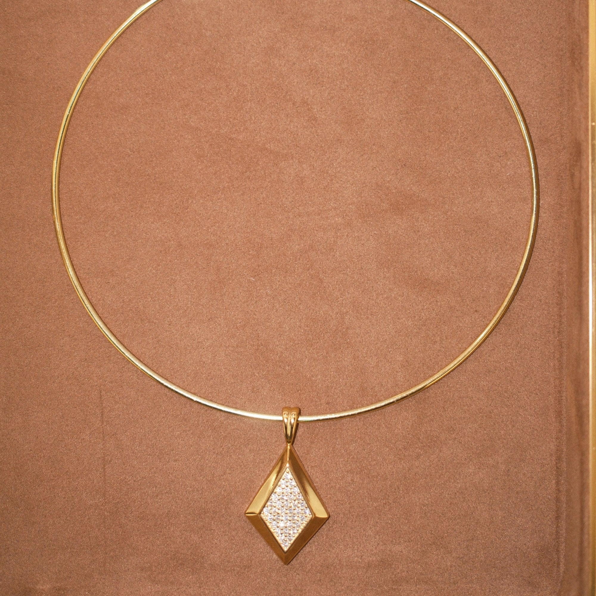 CZ Taylor pendant on a thin gold cuff necklace on brown