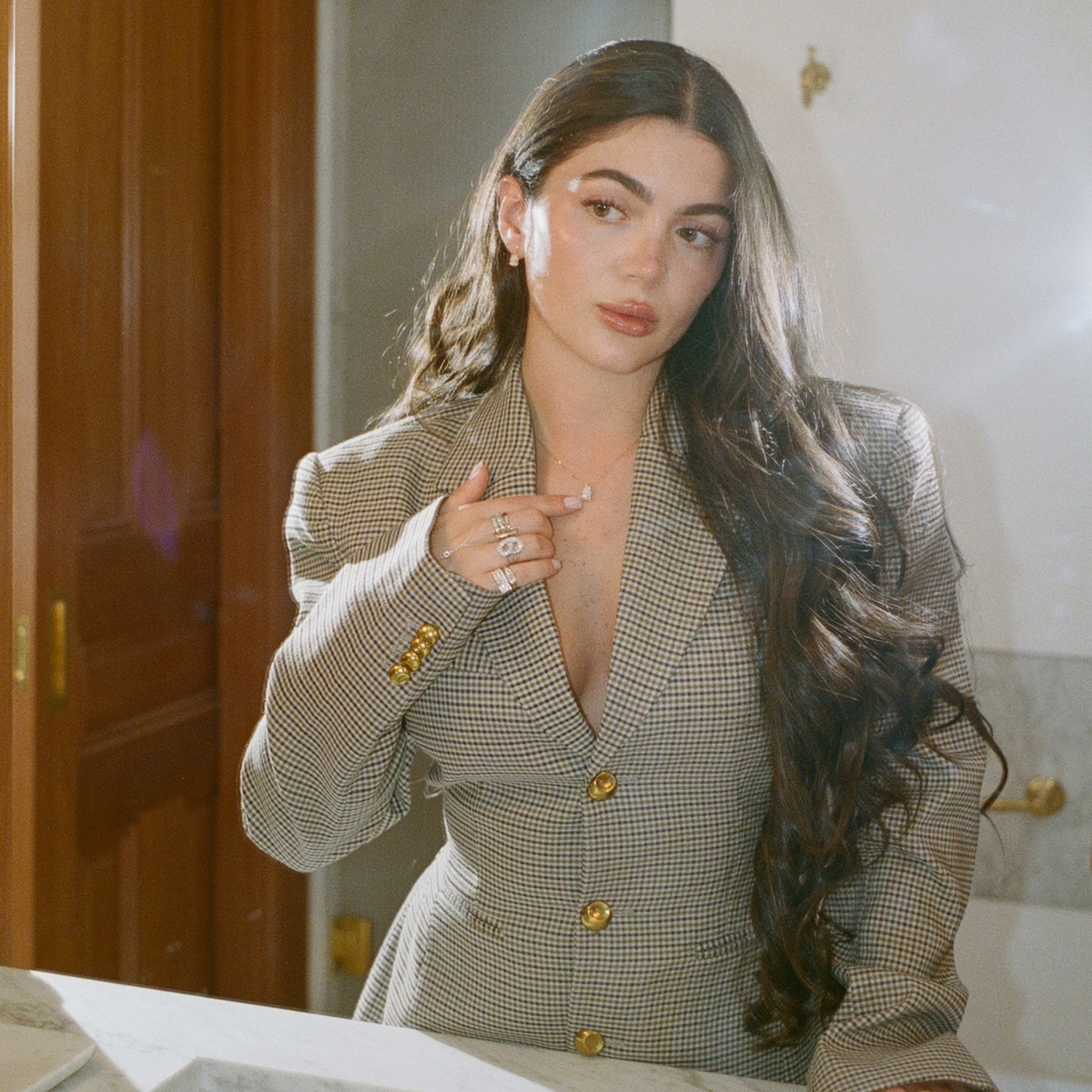 Model in a houndstooth blazer wearing the Classic Pear Diamond Necklace in 14K solid gold