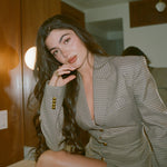 Model seated in a houndstooth blazer wearing the Classic Pear Diamond Necklace
