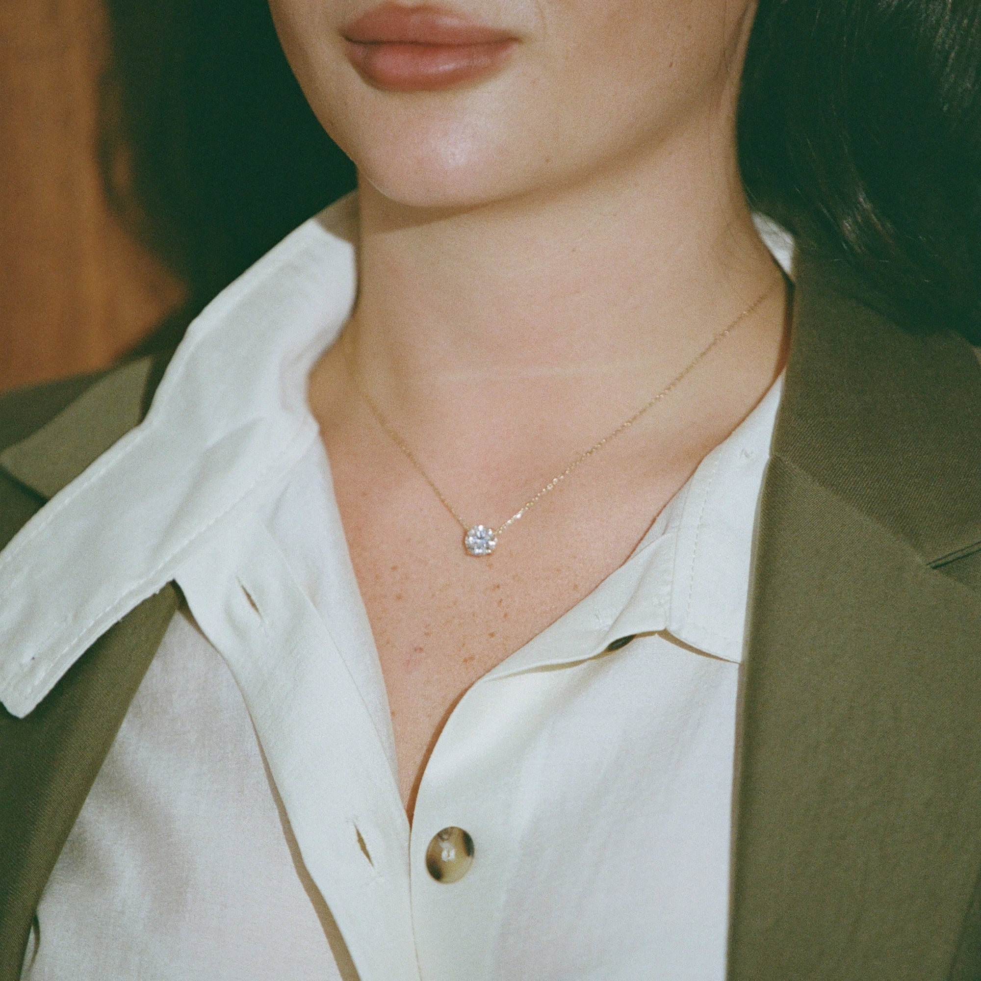 Close-up of the Classic Round Diamond Necklace worn with an open white shirt