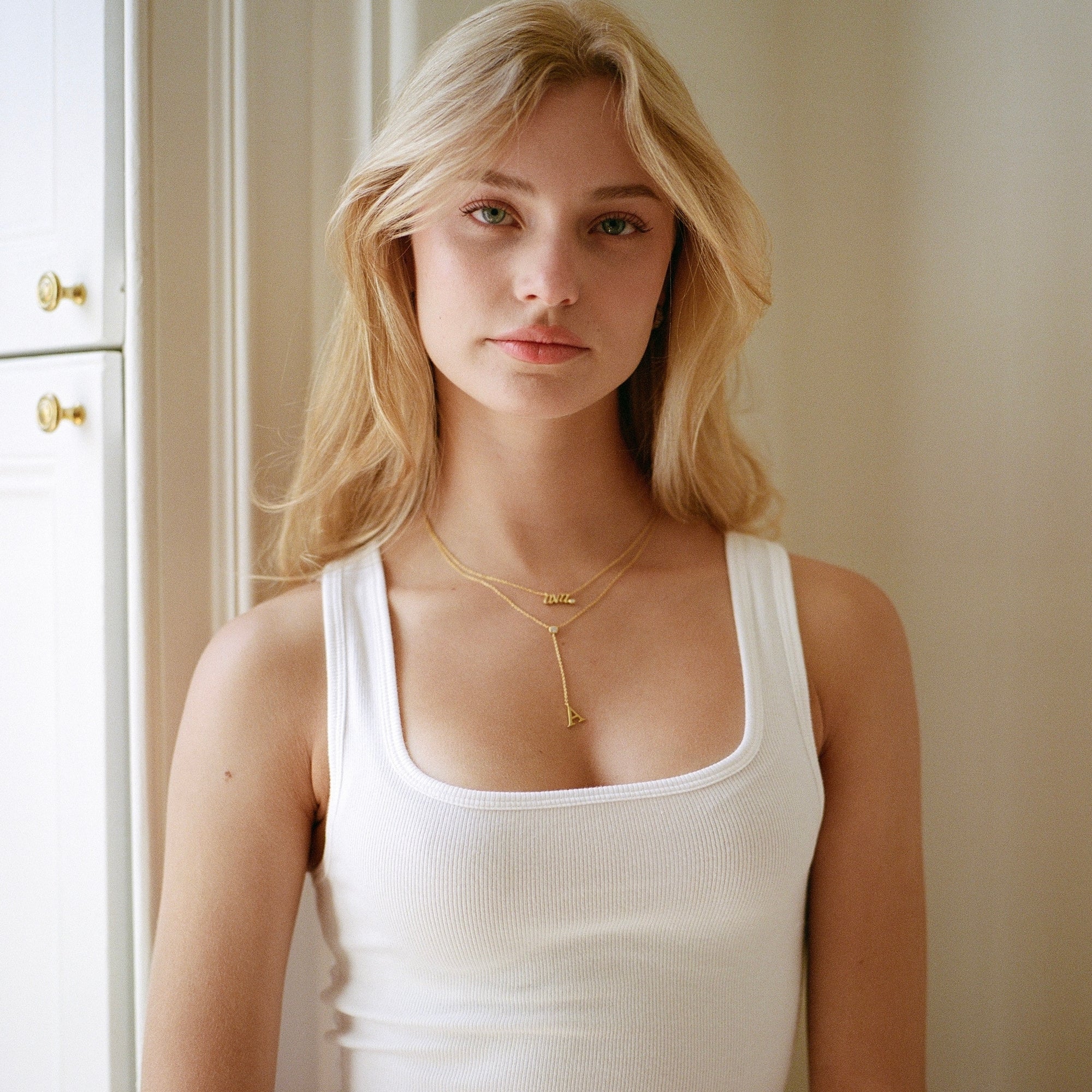 Model in a white tank wearing the Classic Script Nameplate Necklace
