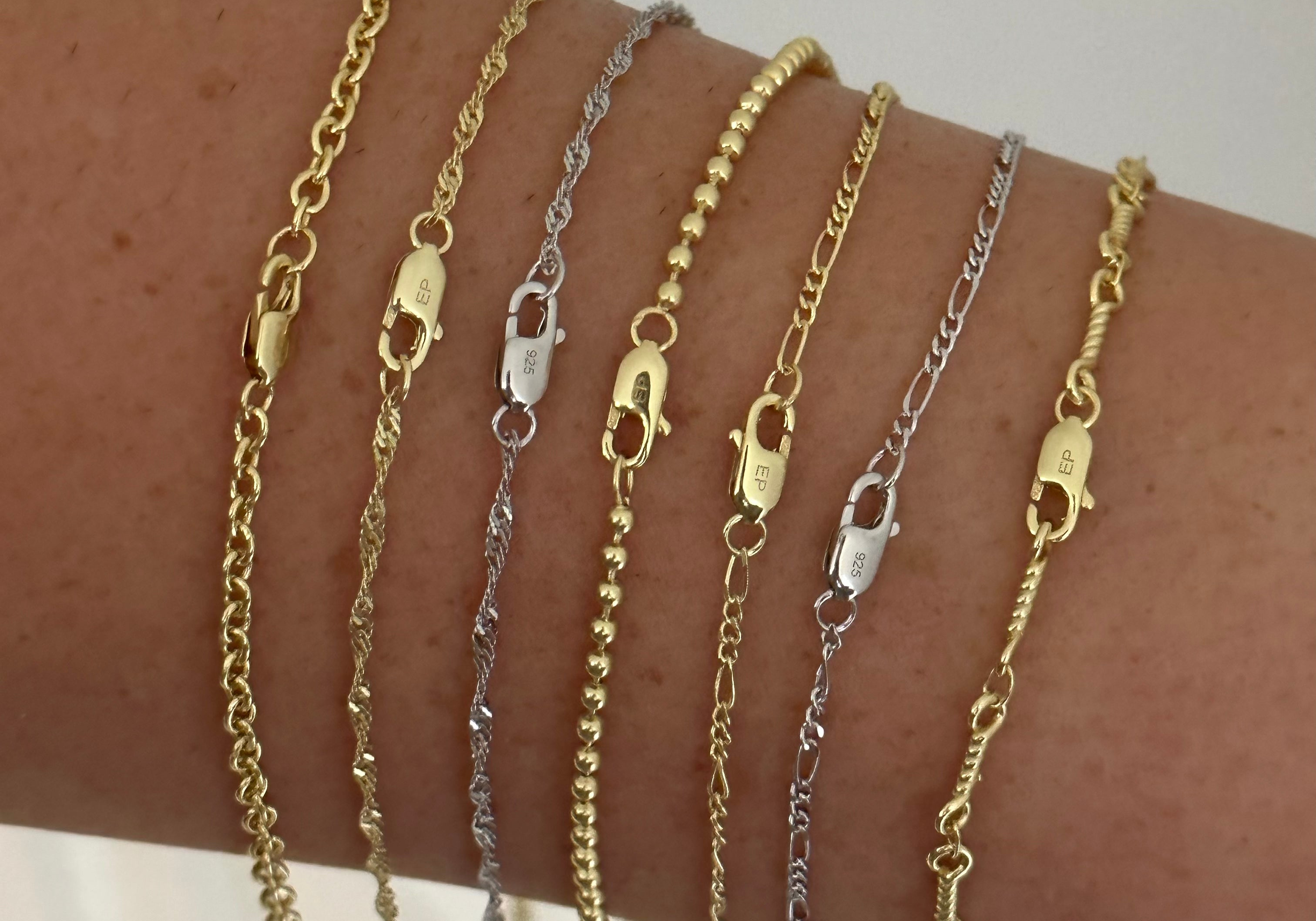 Dainty Chain styles in gold and silver held side by side to compare