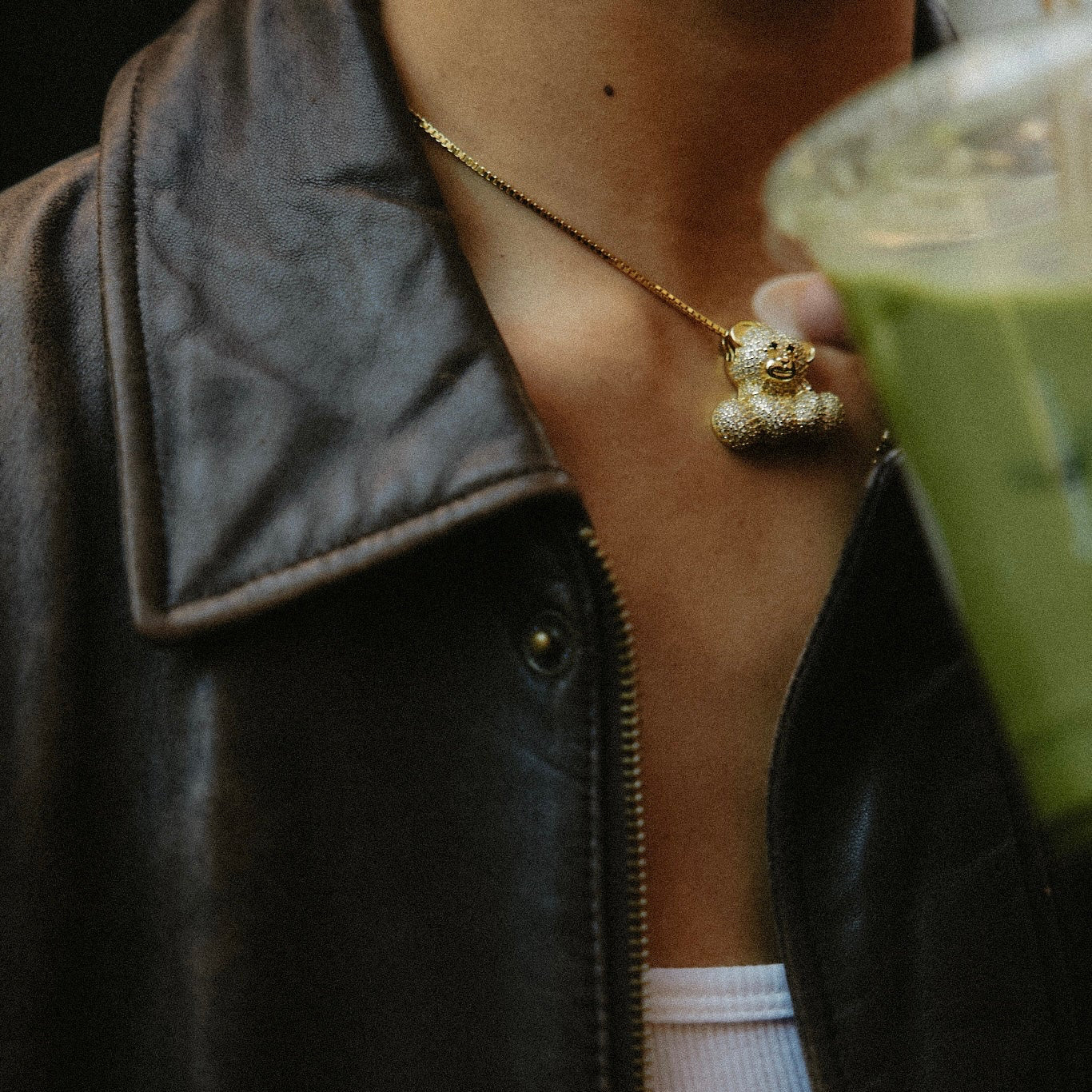 Model in a leather jacket with a matcha wearing the Iced Jumbo EP Teddy Necklace