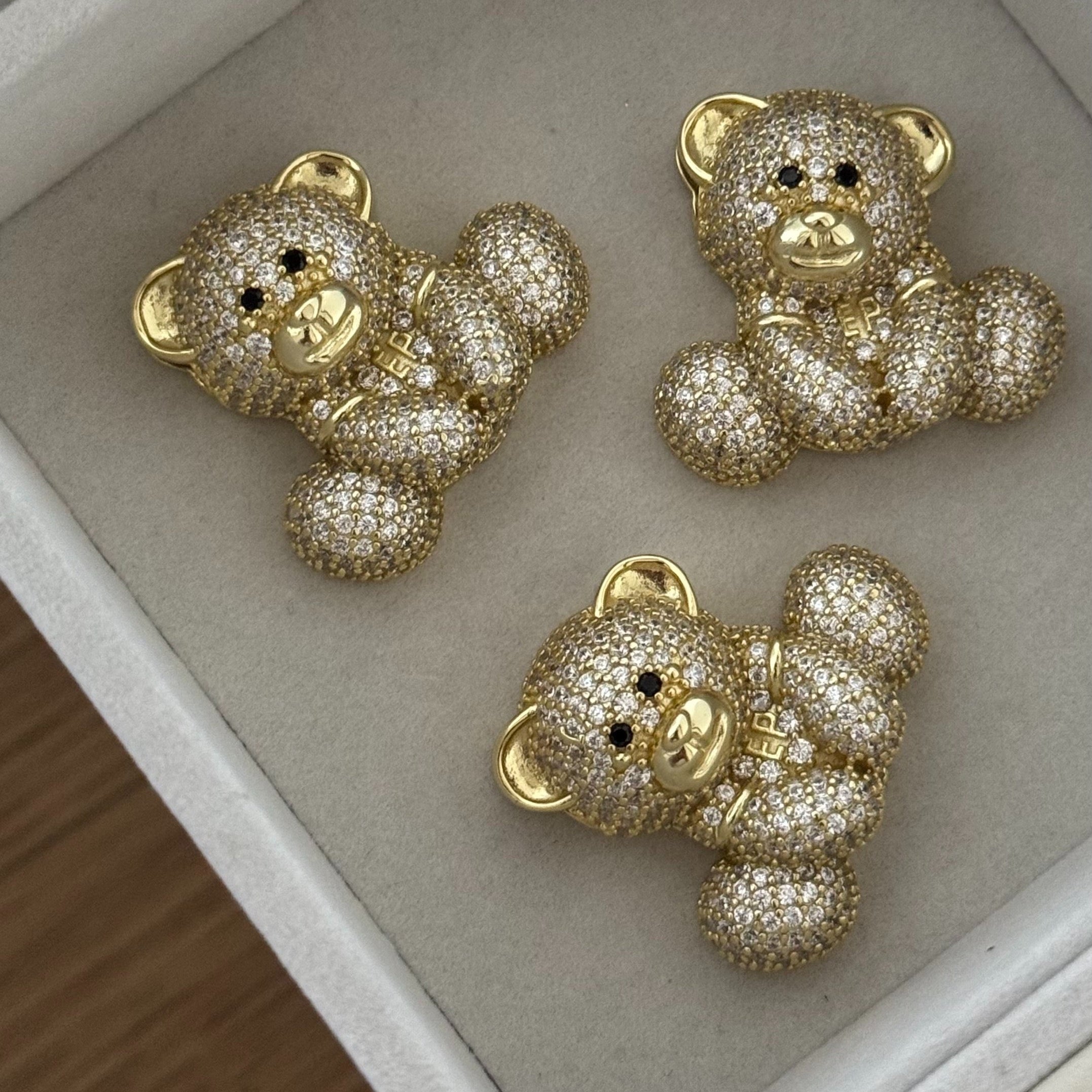 Three gold Iced Jumbo EP Teddy pendants in a jewelry tray