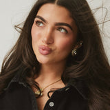 Model in black wearing the Iced Jumbo EP Teddy Necklace and gold earrings