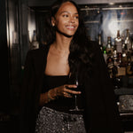 Woman at a night out wearing a dainty iced script initial necklace