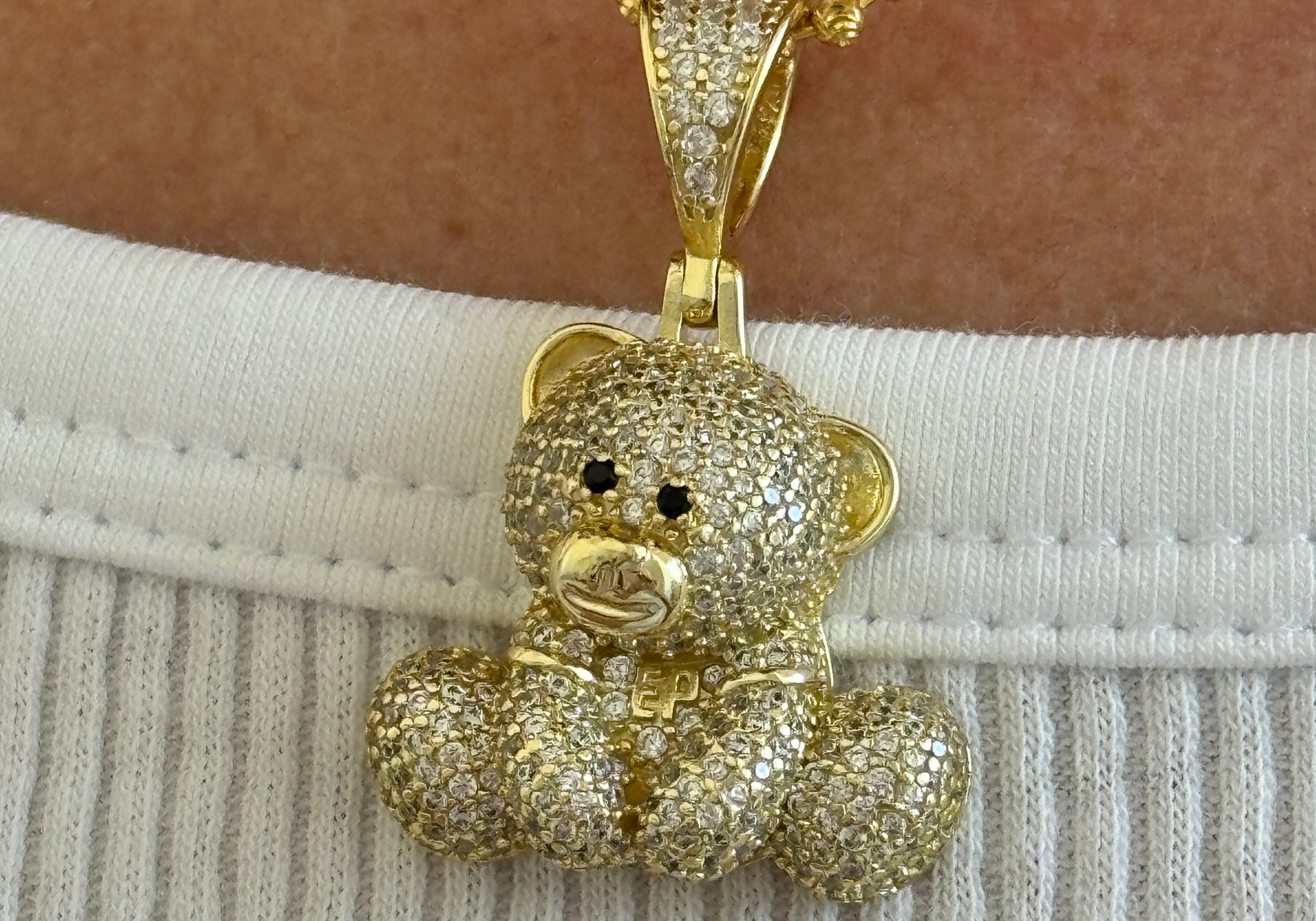Close-up of the gold Iced EP Teddy pendant on a ball beaded chain, worn with a ribbed top
