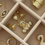 Iced EP Teddy Necklace pendant in a jewelry tray with other EP Jewels gold CZ pieces