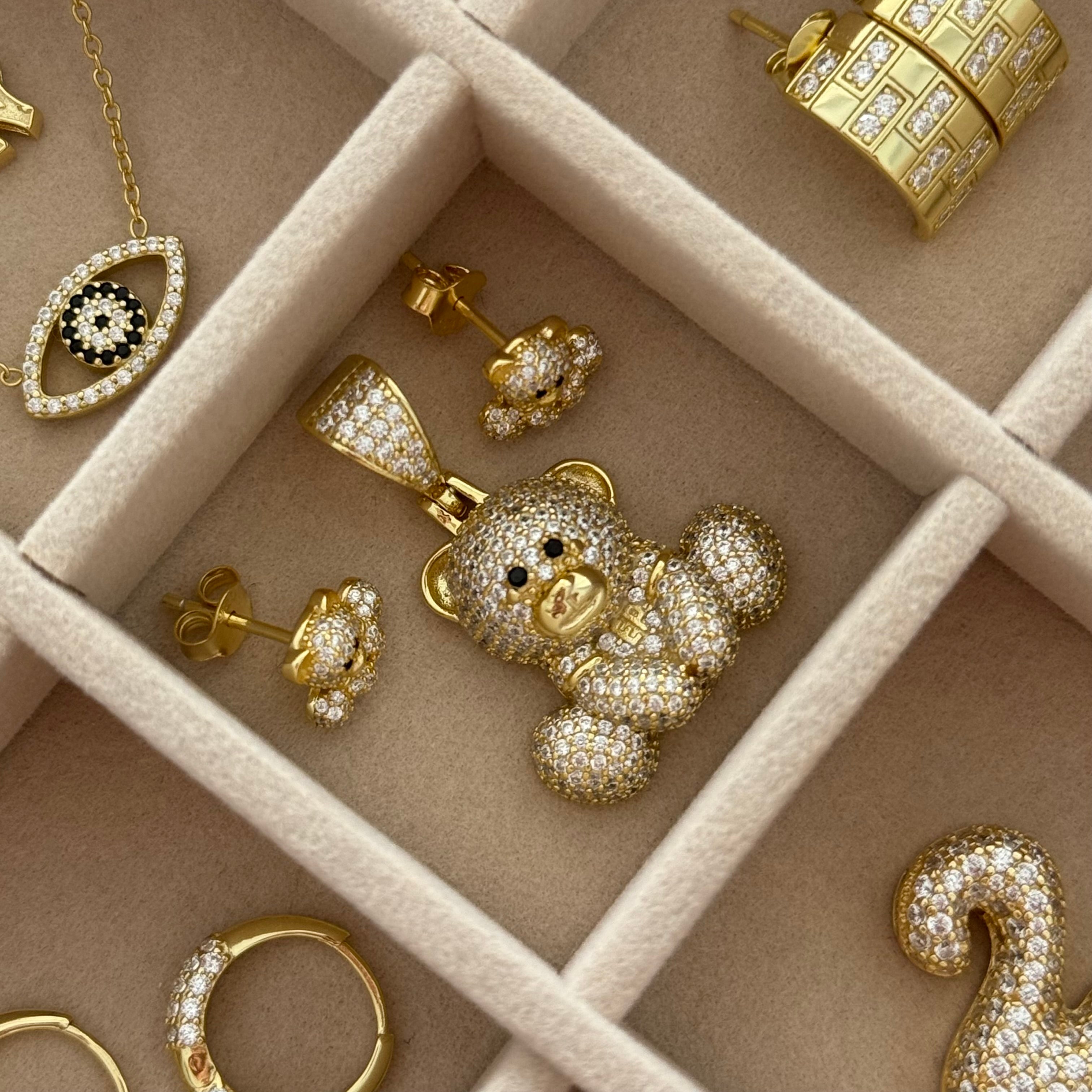 Iced EP Teddy Necklace pendant in a jewelry tray with other EP Jewels gold CZ pieces