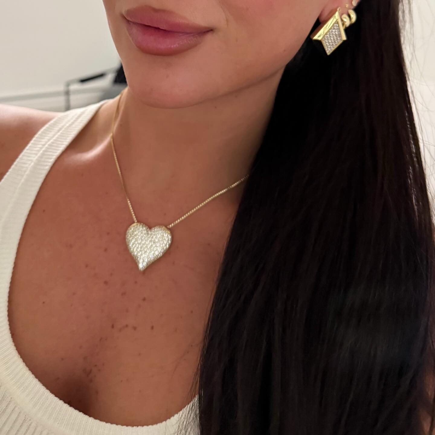 Model wearing the gold Iced Jumbo Heart Necklace with a cream tank