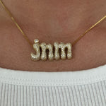 Model wearing the gold Iced Jumbo Initials Necklace in jnm with a white tee