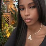 Woman wearing a gold iced jumbo letter A necklace