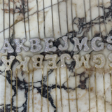 Iced jumbo CZ block letters displayed on marble