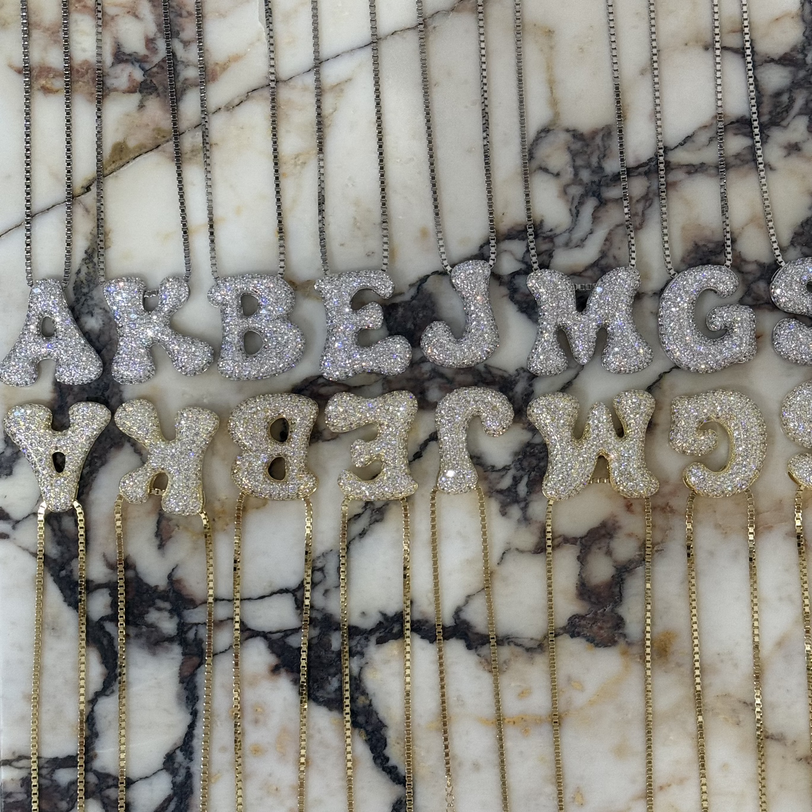 Iced jumbo CZ block letters displayed on marble