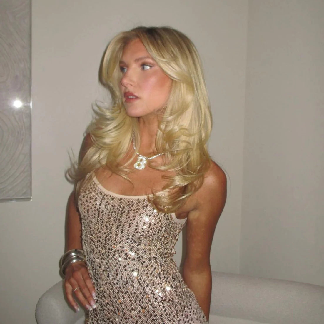Model wearing a gold iced jumbo letter necklace with a sequin dress