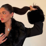 Model wearing an iced jumbo letter necklace with a black faux fur coat