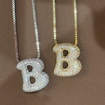 Iced jumbo letter B necklaces in silver and gold side by side, silver available during monthly reopens