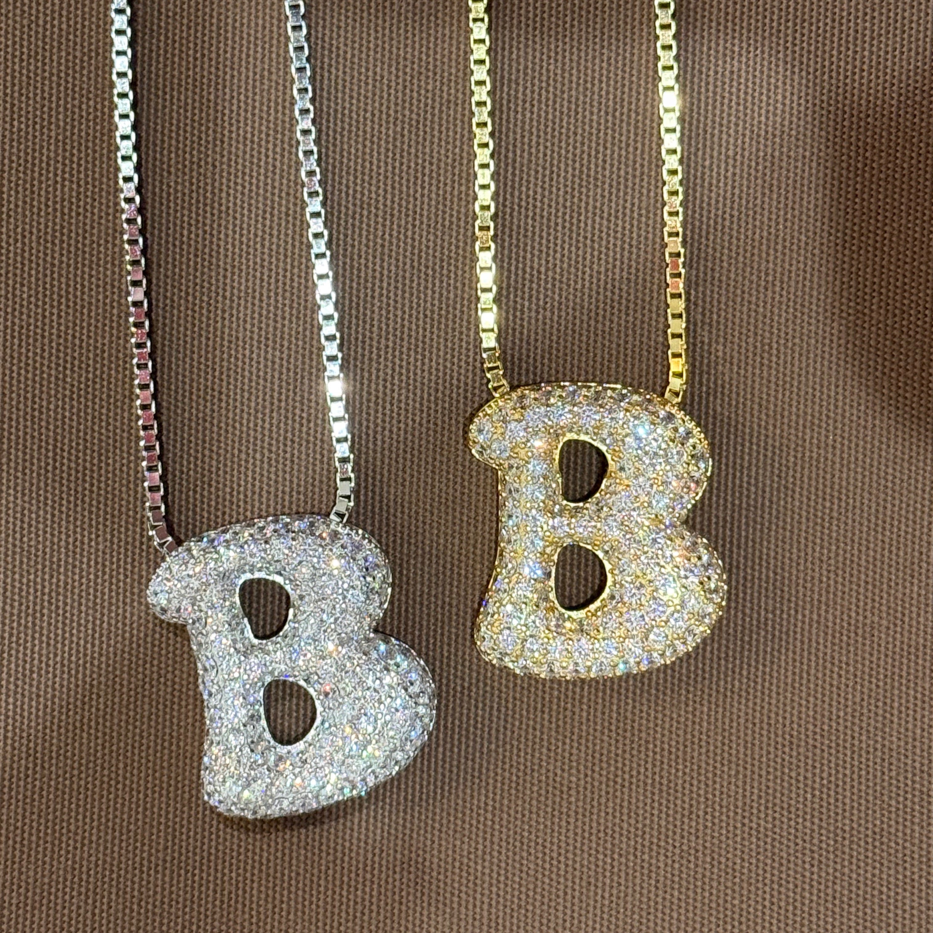 Iced jumbo letter B necklaces in silver and gold side by side, silver available during monthly reopens