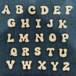 Iced medium jumbo letters A to Z laid out on denim