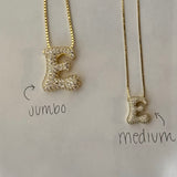 Jumbo and medium iced letter E necklaces side by side to compare sizes