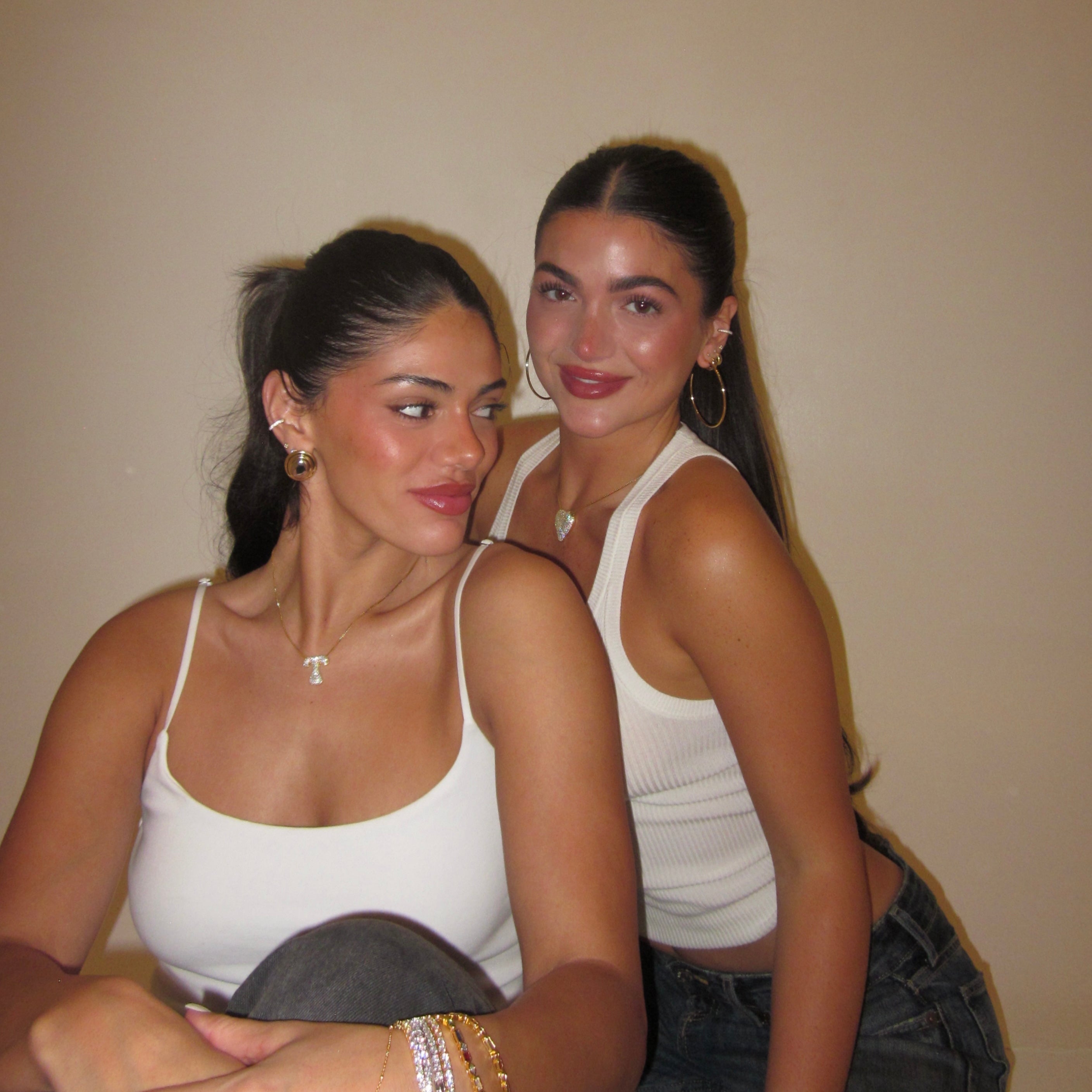 Two friends wearing iced medium jumbo letter necklaces