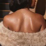 Lariat Drop Necklace worn down the back with an off-shoulder faux fur top