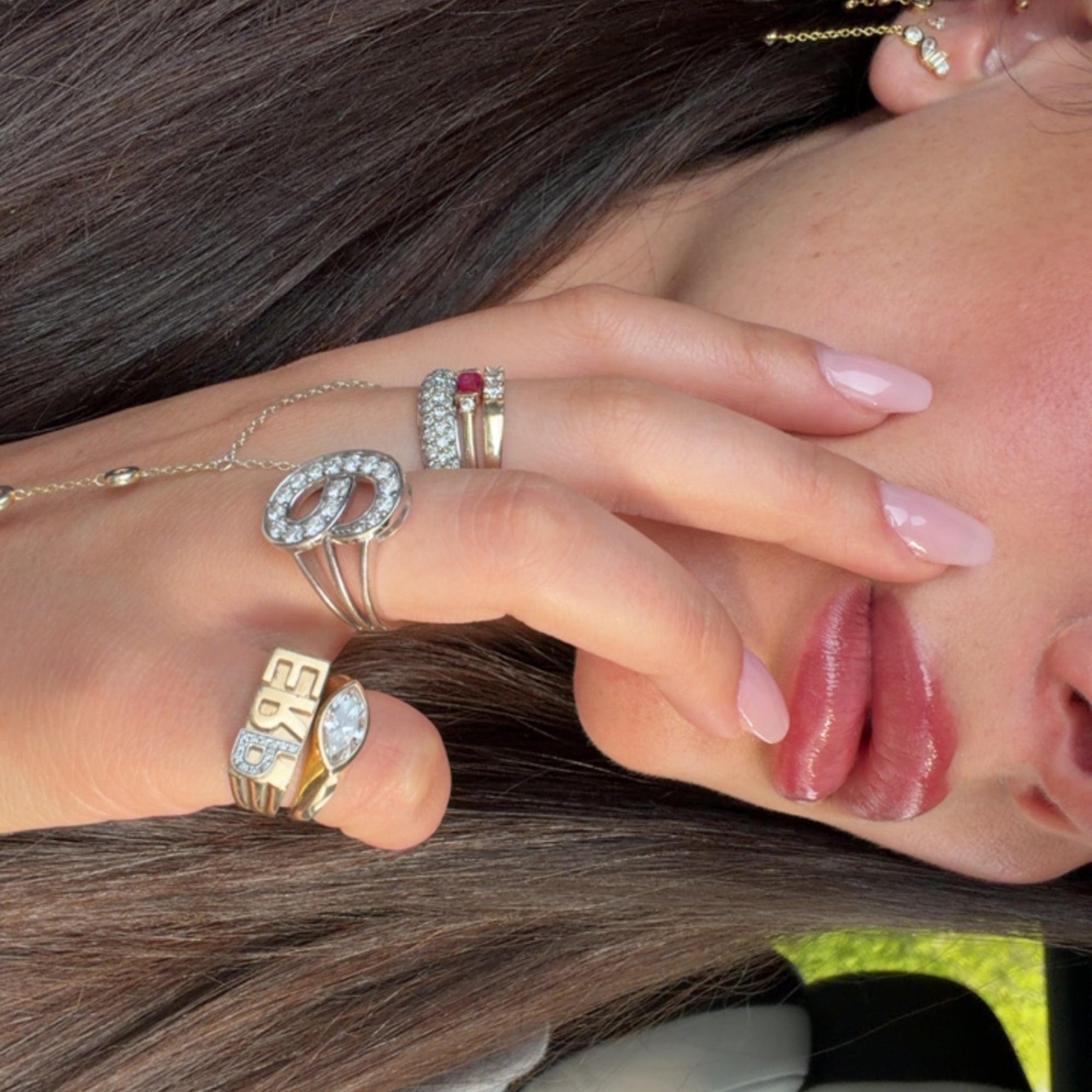 Close-up of EP Timeless 14K solid gold diamond rings stacked on the hand, including letter pinky rings
