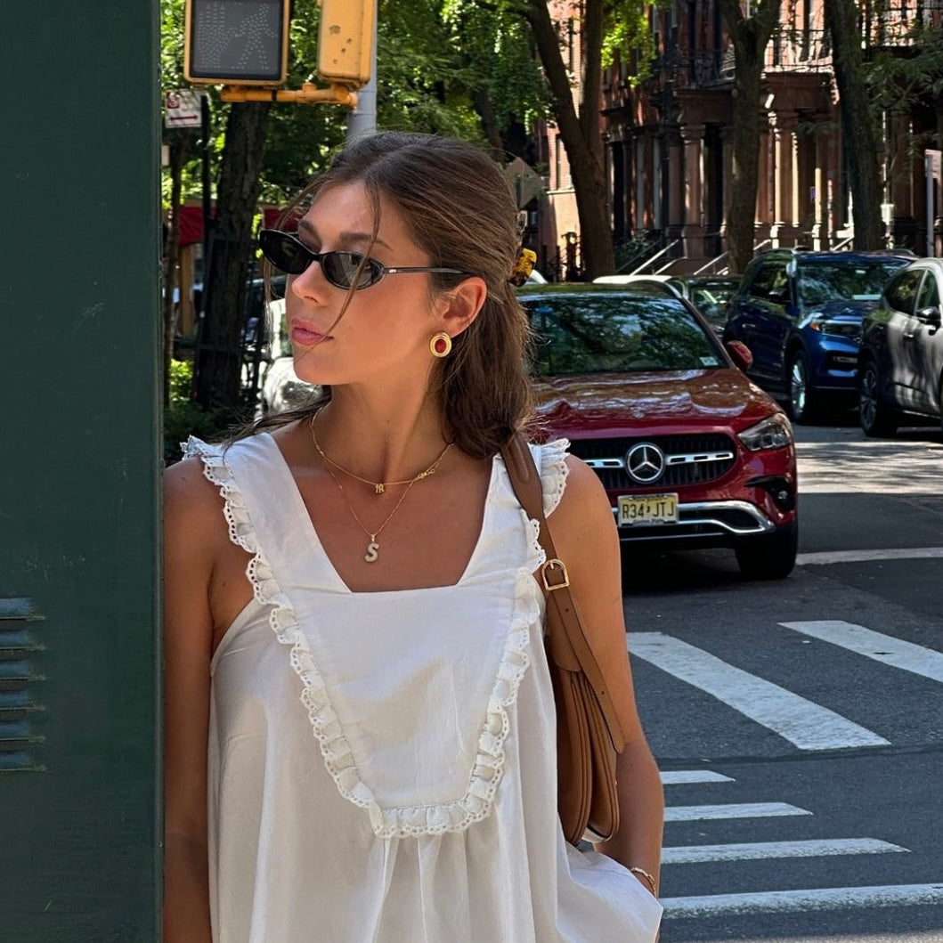 Model in a white sundress on a city street wearing the Mini NY Yankees Necklace