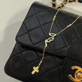Mother Mary Rosary Necklace draped over a black quilted handbag