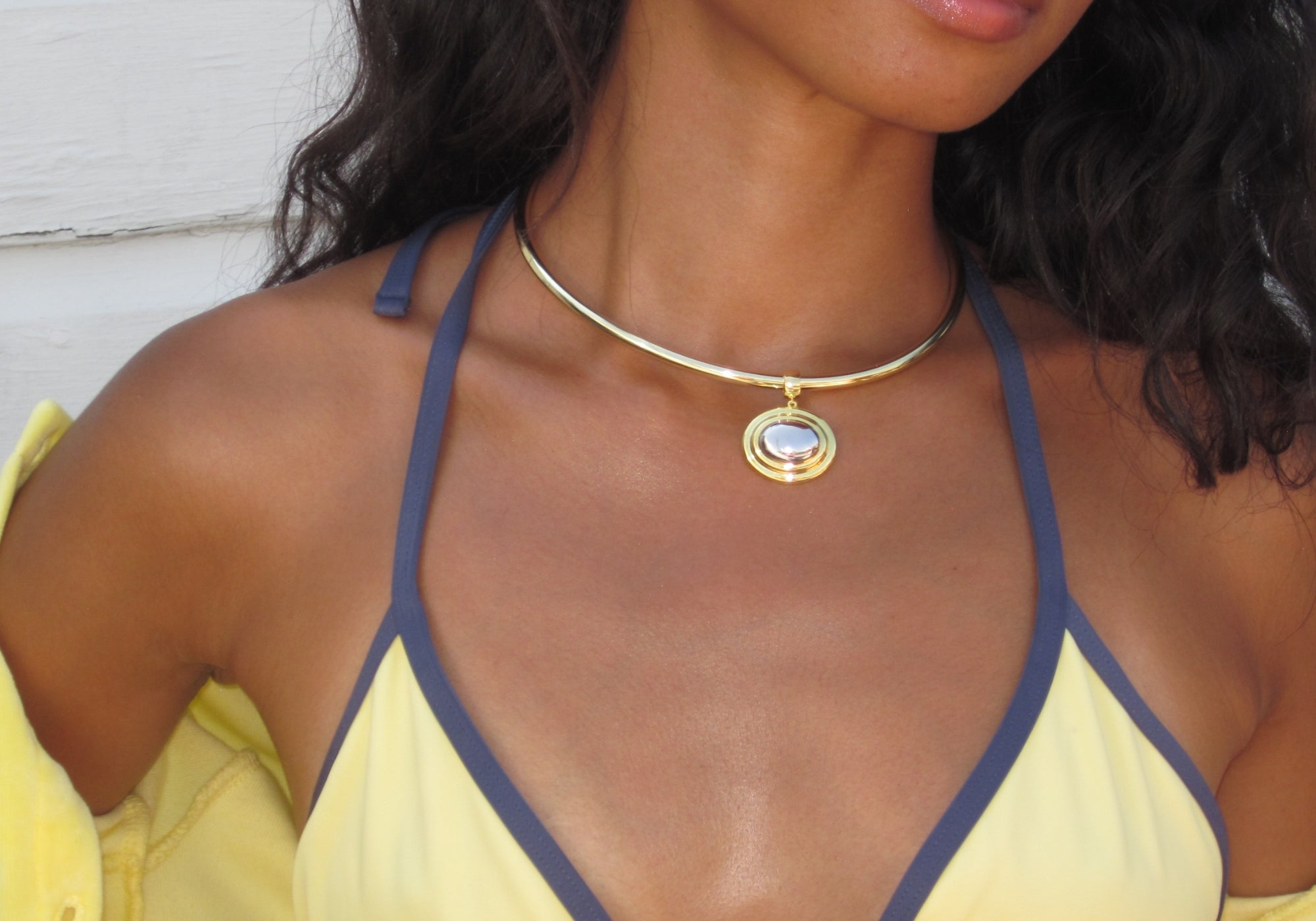 Model in a yellow bikini wearing the Oval Eclipse Cuff Pendant