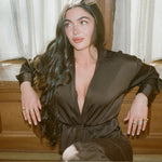 Model in a brown satin robe wearing the Pear Dangle Diamond Necklace in 14K solid gold
