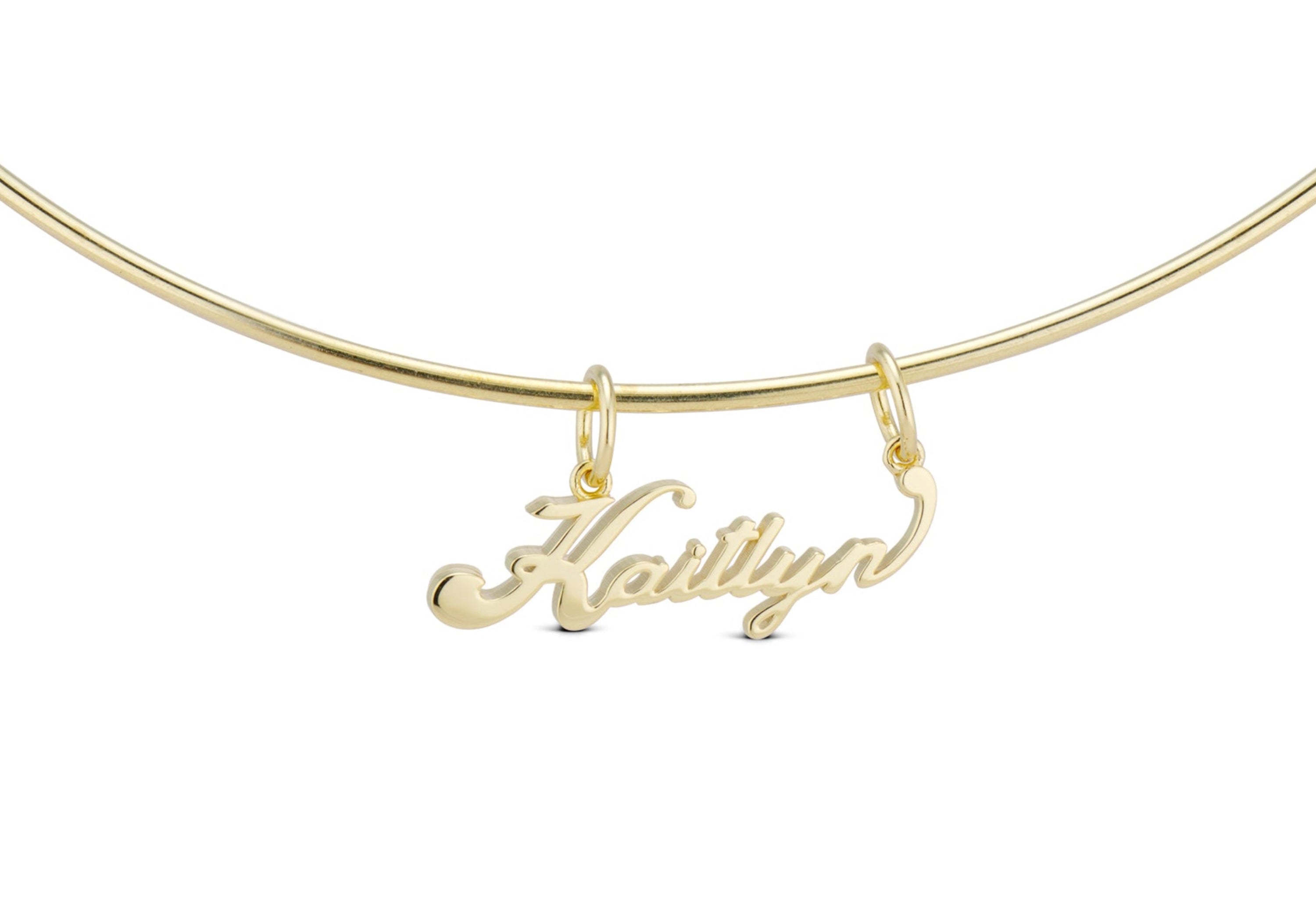 Signature Script Nameplate Charm on a gold cuff