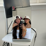 Two friends taking a mirror selfie in EP Teddy Trucker Hats