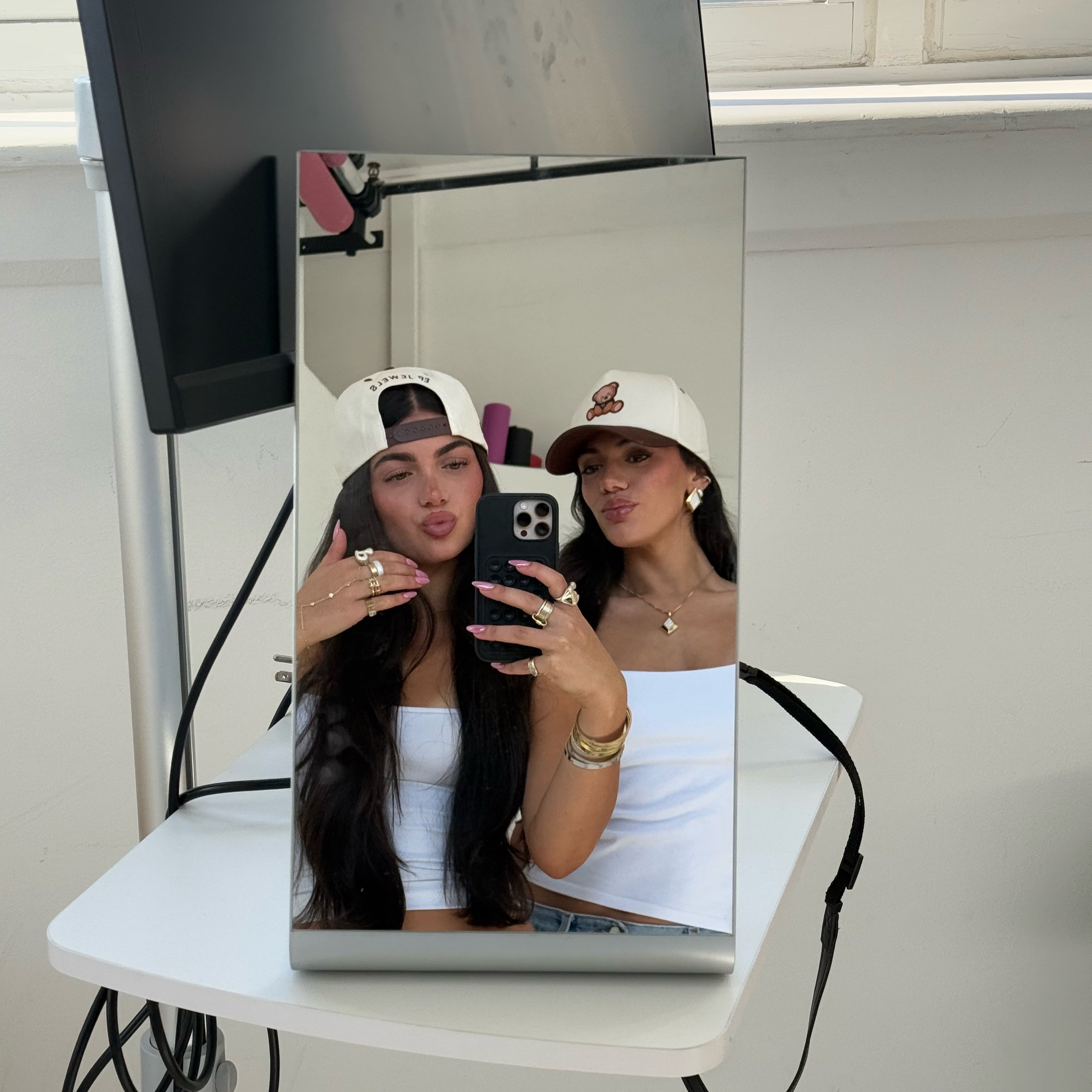 Two friends taking a mirror selfie in EP Teddy Trucker Hats