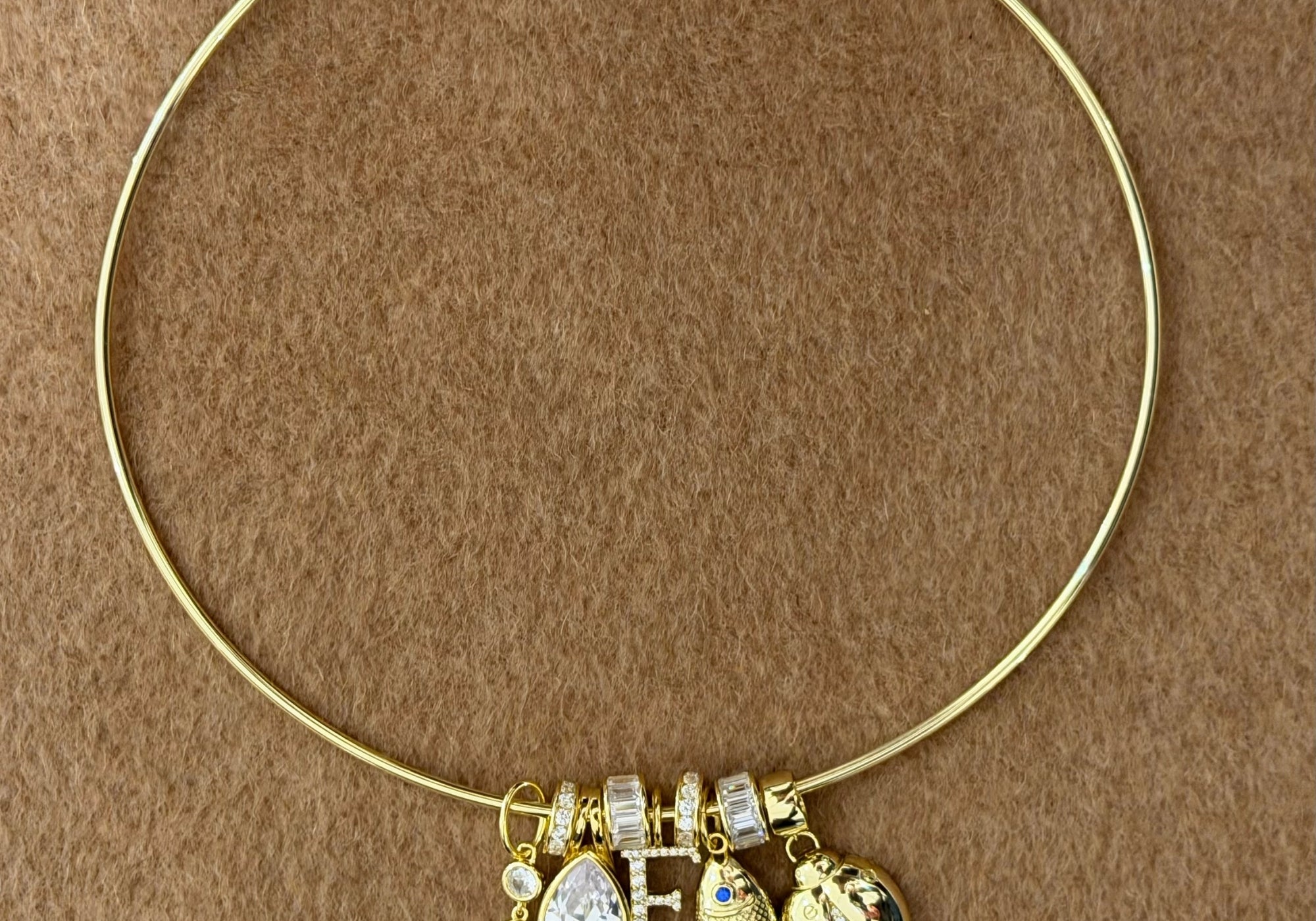 Thin gold cuff necklace stacked with CZ slider charms and pendant charms